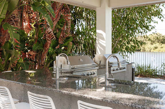 an outdoor kitchen with a grill and a sink