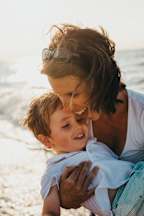 a mother holding her son on the beach