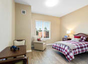 Thumbnail 2 of 5 - a bedroom with a bed and a chair and a table