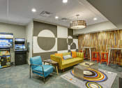 Thumbnail 4 of 9 - a living room with couches and chairs and a video game room