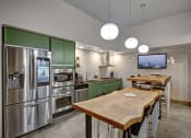 Thumbnail 2 of 9 - a kitchen with stainless steel appliances and a wooden table
