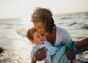 Thumbnail 1 of 4 - a mother holding her son on the beach