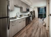 Thumbnail 9 of 44 - model kitchen with stainless steel appliances at Topaz Apartments, Los Angeles