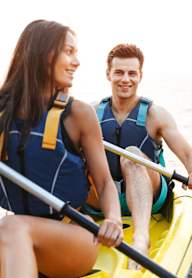 A man and a woman are kayaking on the water.