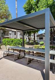 a picnic area with a table and benches under an awning