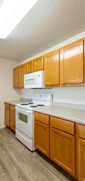 A kitchen with wooden cabinets and white appliances.