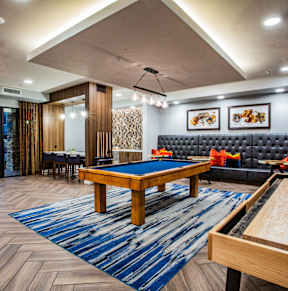 A room with a pool table and a couch.