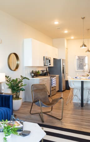 a living room and kitchen with a blue couch and a table