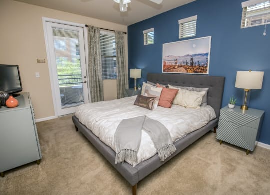 a bedroom with blue walls and a bed with pillows at Loreto & Palacio Apartments, Las Vegas, NV 89149