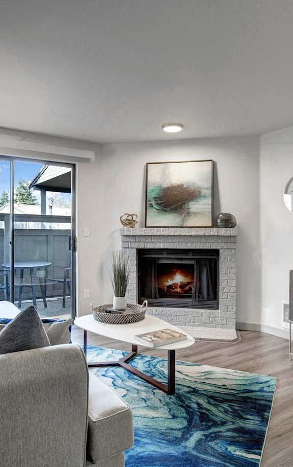 a living room with a fireplace and a sliding glass door to a balcony