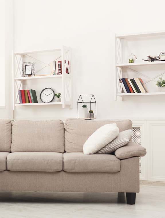 A large golden painting hangs above a grey couch in a living room.