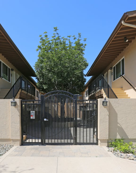 a gate in front of a house with a tree