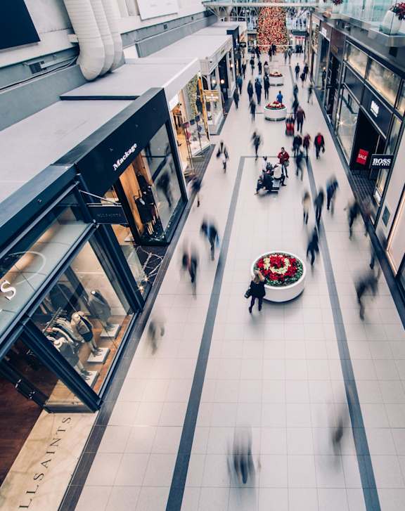 A blurry image of a shopping mall with people walking.