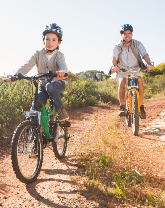 a man and a boy riding bikes on a dirt road at Haven Park, California, 92411