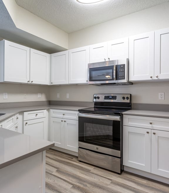 a kitchen with white cabinets and stainless steel appliances