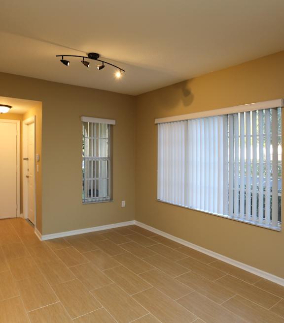 A room with a window covered by white blinds and a ceiling fan.