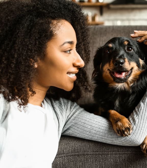 a woman sitting on a couch with her dog