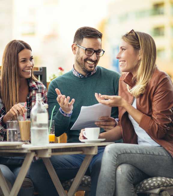 Four people are sitting at a table, enjoying a meal and conversation.