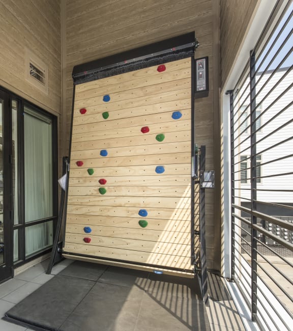 a climbing wall in the lobby of a building with glass doors