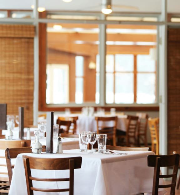 an empty restaurant with white tables and chairs