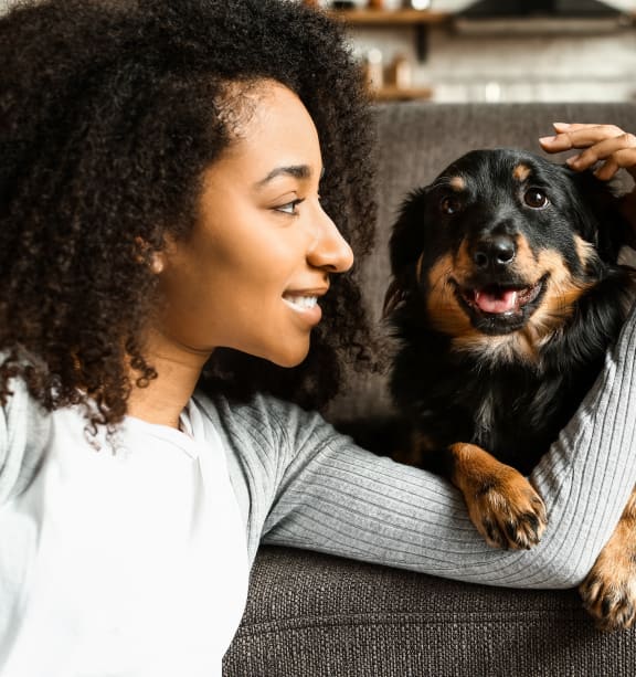 a woman sitting on a couch with her dog