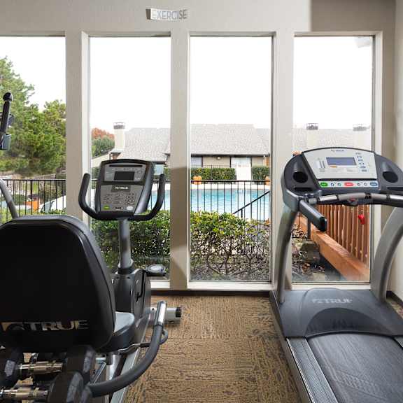 a home gym with exercise equipment and a tv