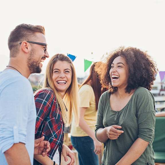 A group of people are standing together and laughing.