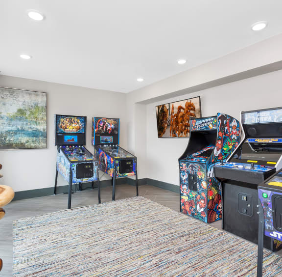 a room with arcade games and a table with chairs