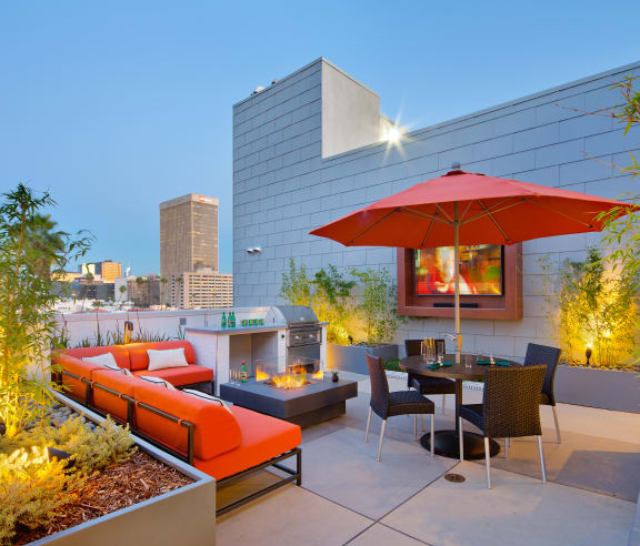 a rooftop patio with a fire pit and a view of the los angeles skyline
