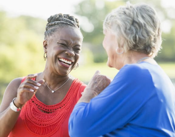 two women laughing and talking to each other