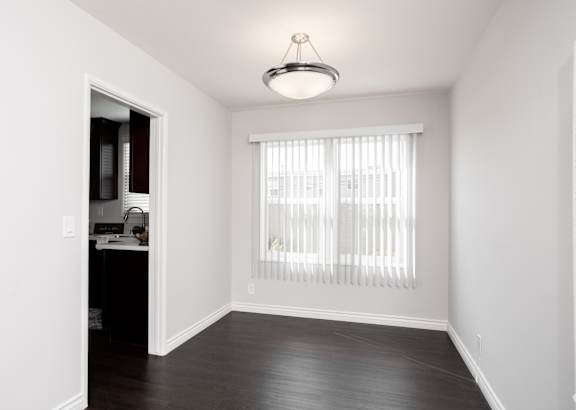 a kitchen with black cabinets and stainless steel appliances and a white counter top