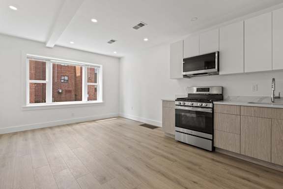 A kitchen with a stove, oven, and microwave.