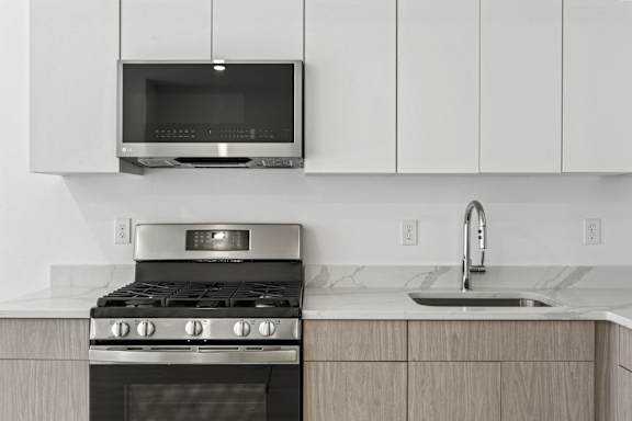 A modern kitchen with a stove, oven, and microwave.