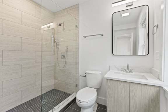 A bathroom with a toilet, sink, and mirror.