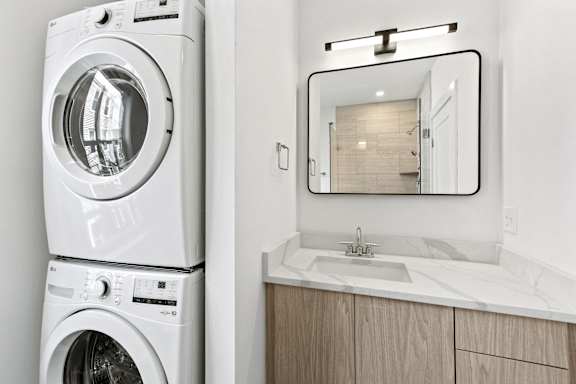 A white washing machine and dryer in a laundry room.