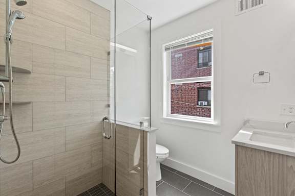 A bathroom with a walk-in shower and a window.