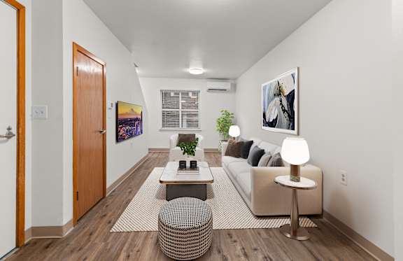 A living room with a couch, a coffee table, and a potted plant.