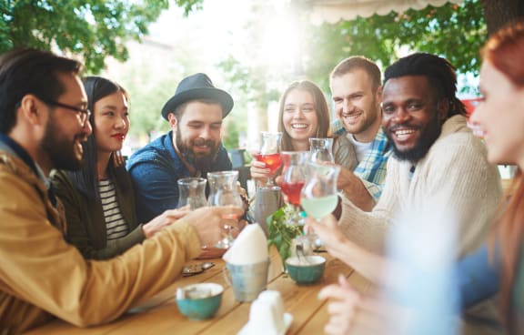 a group of people sitting around a table drinking wine