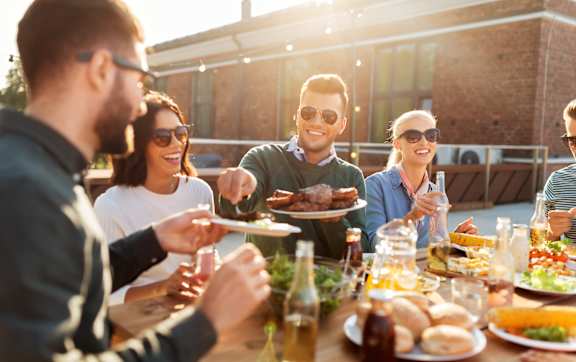 A group of people enjoying a meal together at an outdoor table.