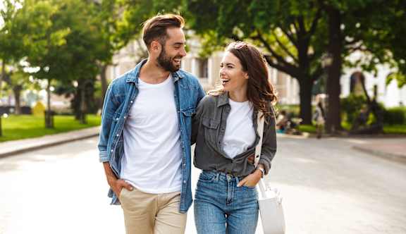 A man and a woman are walking together on a sunny day.