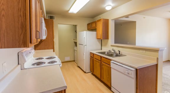 a kitchen with white appliances and wooden cabinets