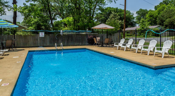 a swimming pool with chairs and an umbrella