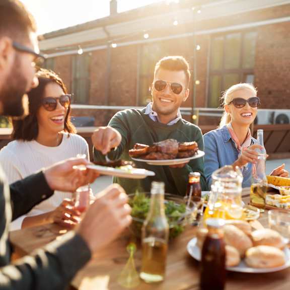A group of people enjoying a meal together at an outdoor table.