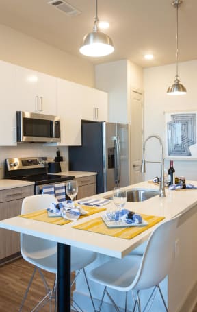 a kitchen with an island and a table with white chairs