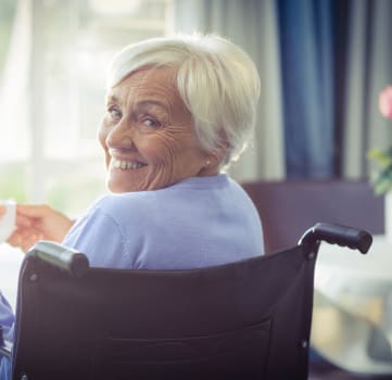 an older woman in a wheelchair holding a cup of coffee