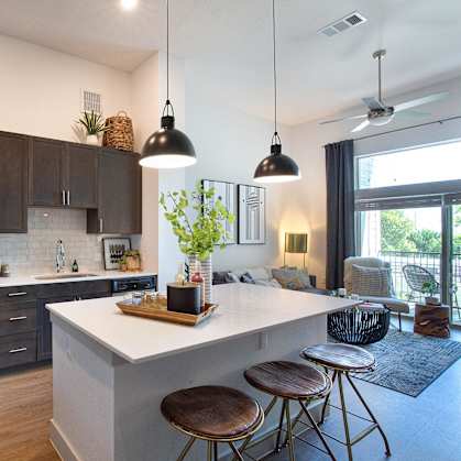 a kitchen and living room with a white island and stools