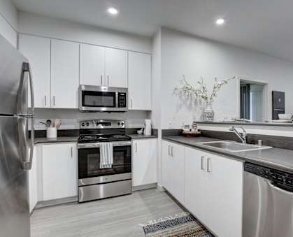 A modern kitchen with stainless steel appliances and white cabinets.