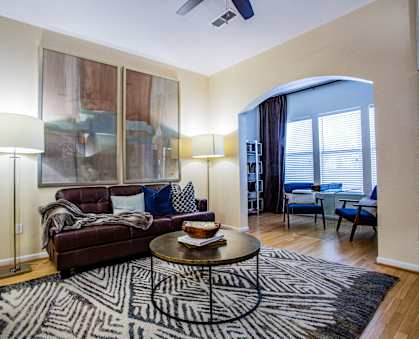 A living room with a couch, a coffee table, and a rug.