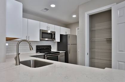 a kitchen with white cabinets and stainless steel appliances