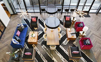 a living room with couches and chairs and a large table and chairs